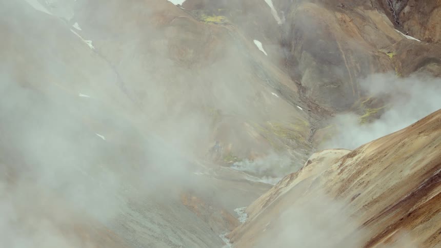 Winding river amidst mountains shrouded in smoke