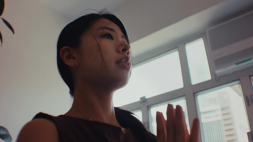A young woman practices yoga indoors at midday the light coming in clean and bright through the windows she moves into a stretch with steady focus her posture calm and controlled as the quiet room holds a soft midday stillness