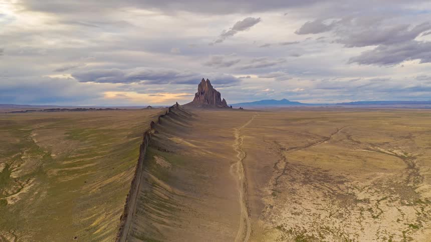 Rock wall and rock formations in the desert under a cloudy sky
