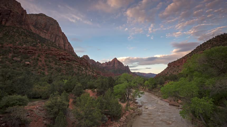 A time lapse of a river in a canyon near mountains