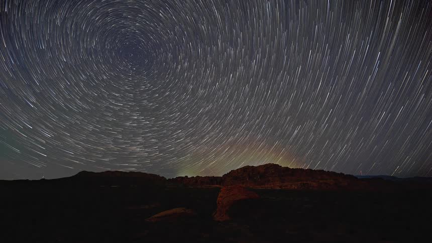 A time lapse of stars above a mountain