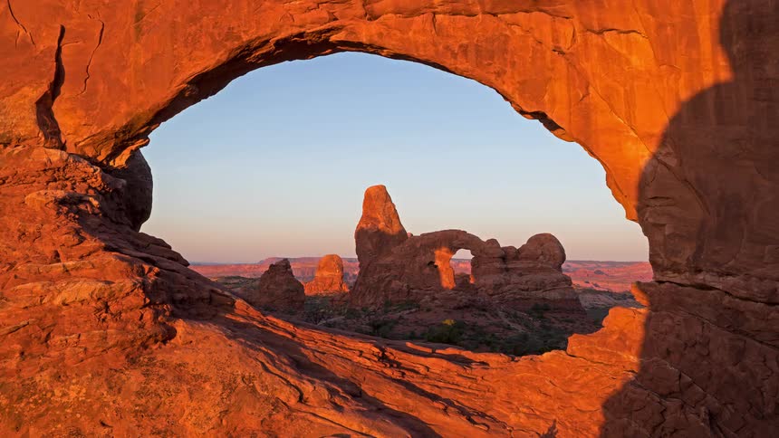 View through a red rock arch of rock formations in the desert