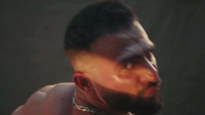The man turns and flexes his muscles