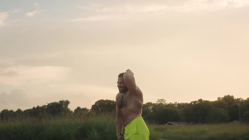 A man flexing and posing outdoors