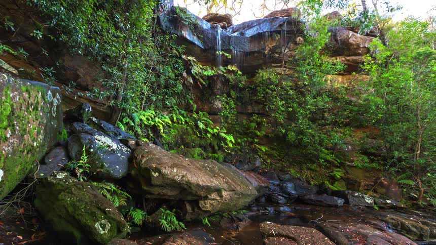 The water flows off the cliff above