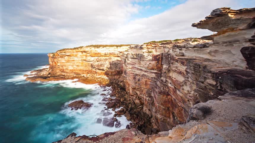 The base of the cliffs are surrounded by ocean water