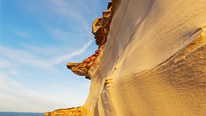 The tall cliff is on the shore