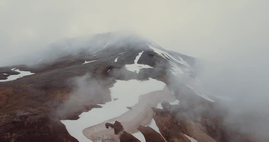The clouds are sitting on the peak of the mountain
