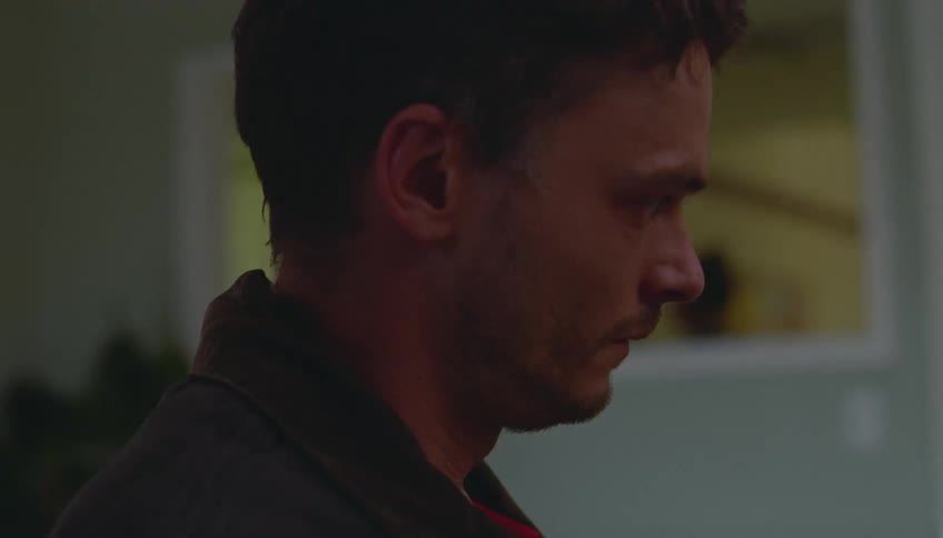A man that looks very nervous sitting in a room