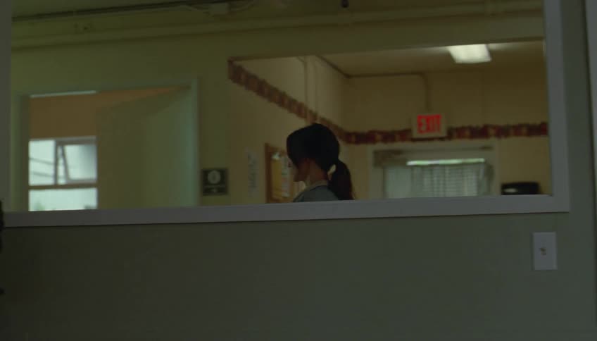 A doctor walking in scrubs down a hallway