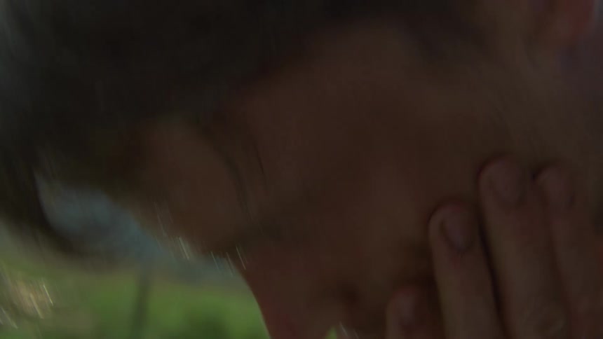 Hands covering the face with water dripping during washing