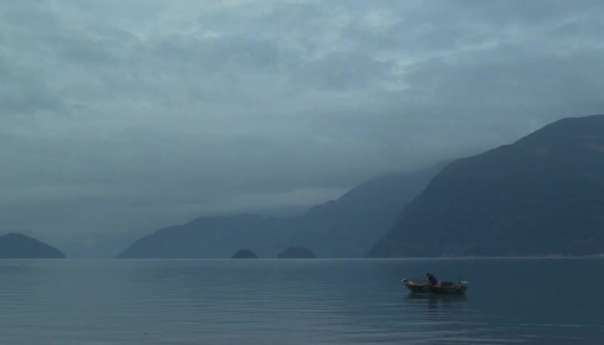 The man pulls the net up into his boat