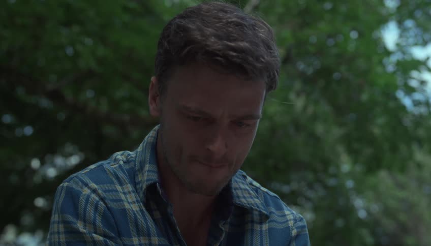 A closeup of a young man as he turns his head and looks over his shoulder
