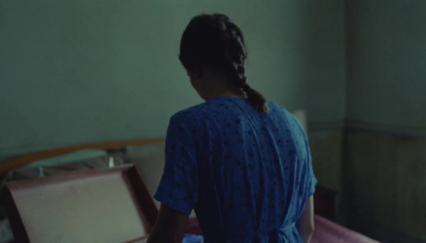 The woman is packing her luggage in the bedroom