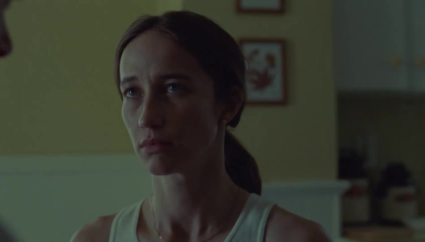 Woman hugging a man with a visible tear on her face in an indoor setting