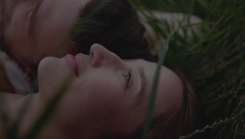 Closeup of a couple lying peacefully on the grass in a park