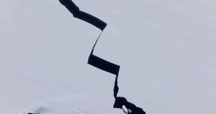 Deep fissure cutting through a snowcovered ice surface