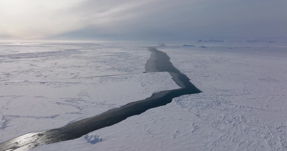 Extensive crack crosses an ice field toward the horizon