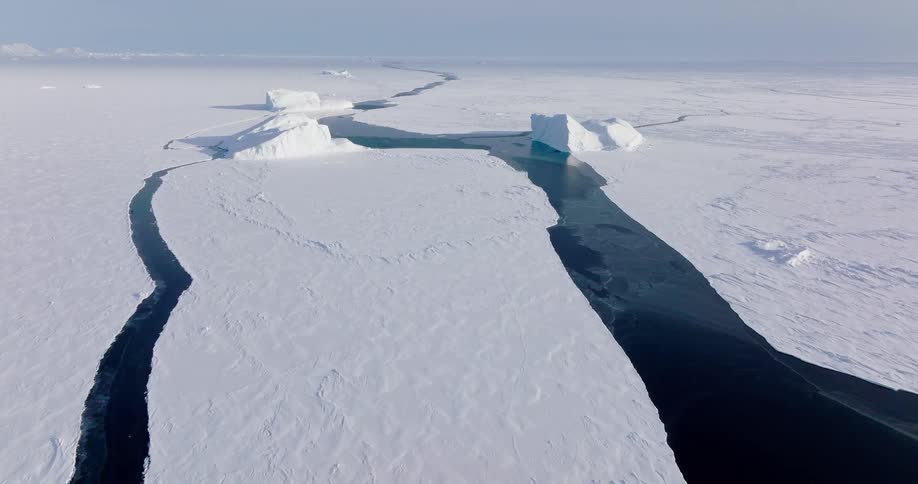 Sunlight shines on cracked ice across the arctic