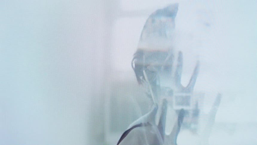The video features a woman performing fluid expressive dance movements through a hazy dreamlike double exposureprismlike geometric patterns overlay her figure as she rotates her arms and tilts her head against a bright ethereal background