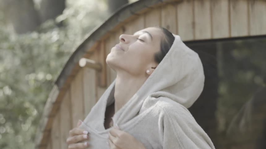 The woman smiles and looks up at the sky