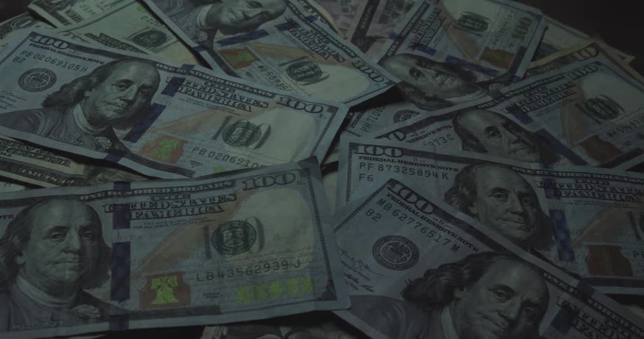 Hundred dollar bills form a slight pile