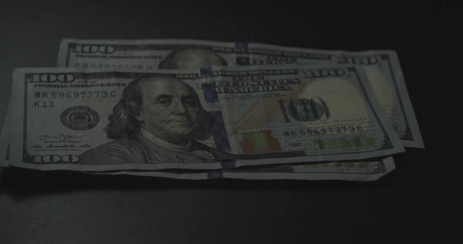 Dollar bills being placed on a table