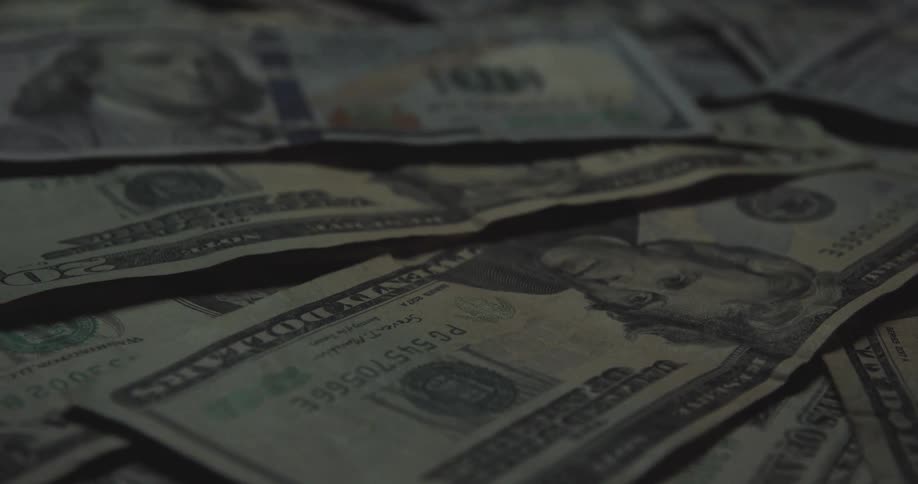 A person picking up cash off of a table