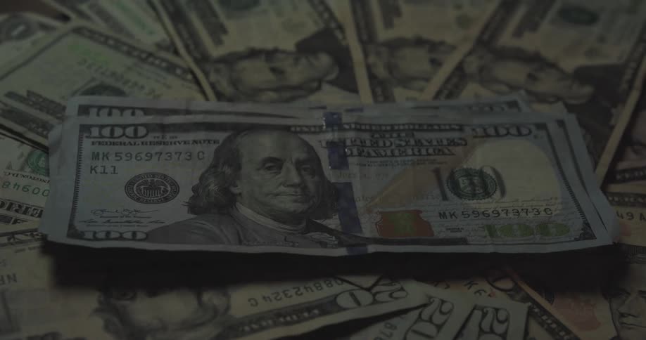 A person stacking cash on a table