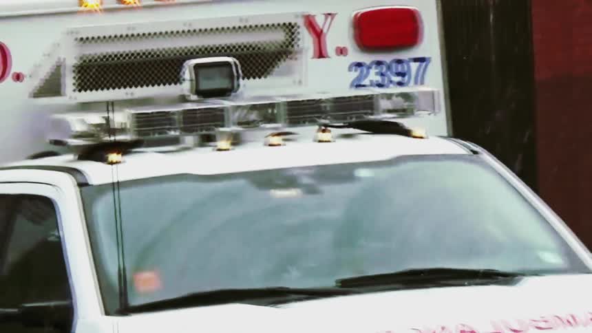 Ambulance with emergency lights activated seen from the front in an urban environment
