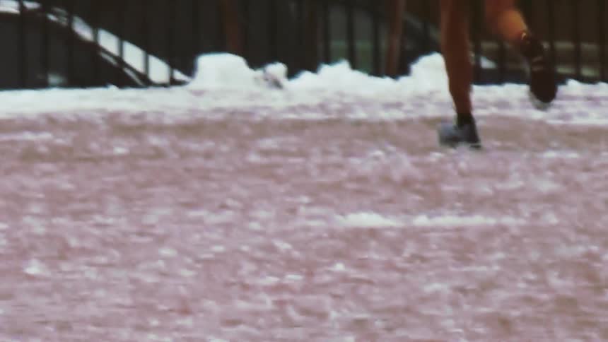 A person jogs through a snow filled park in winter time