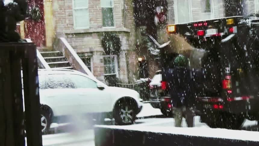 Garbage truck collecting waste during snowfall on a residential street