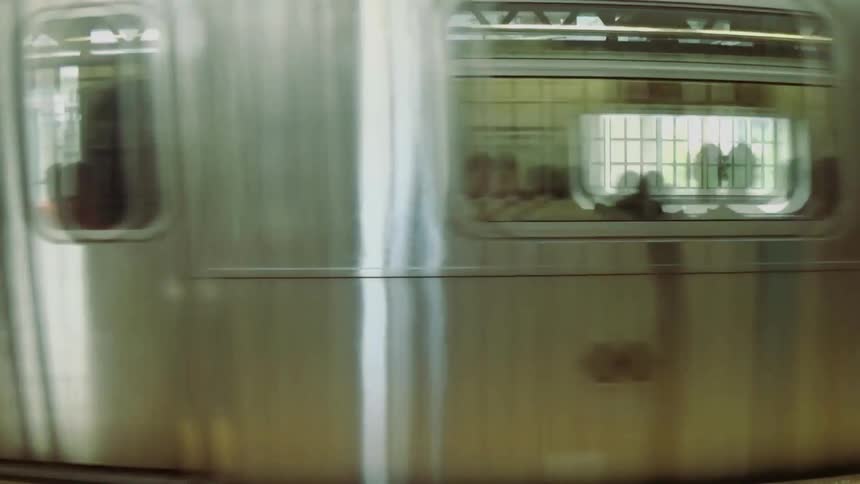 Train moving past an urban station platform