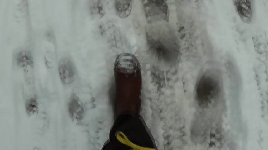 Footstep walking over compacted snow with visible footprints
