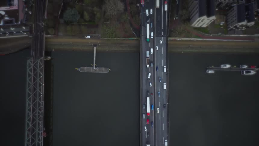 An aerial view of cars driving over a bridge in a city