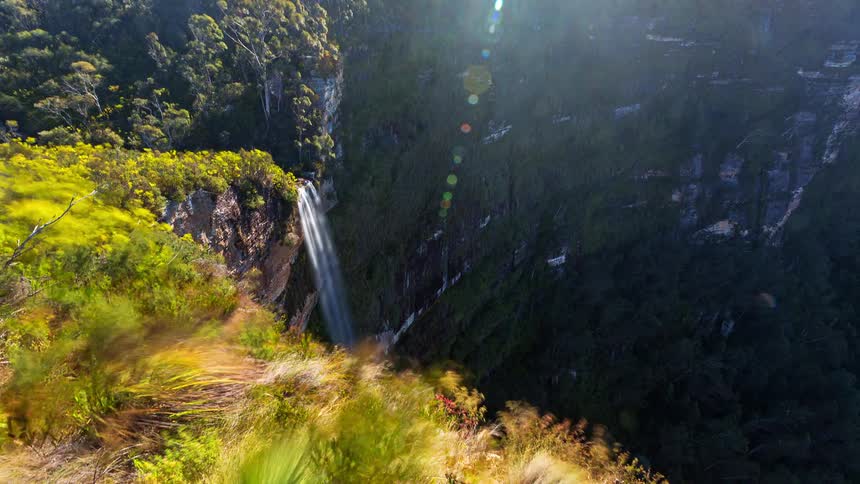 The waterfall pours off the top of the mountain