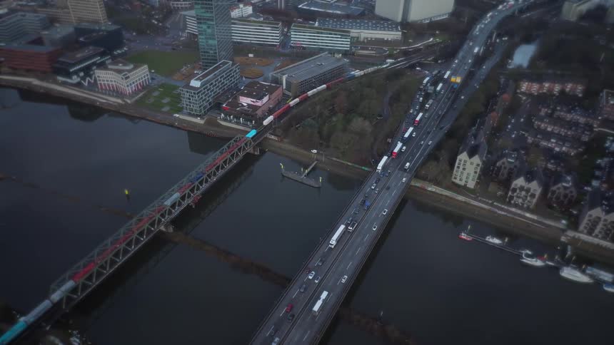 Heavy traffic crossing bridges over a river in an urban area seen from above