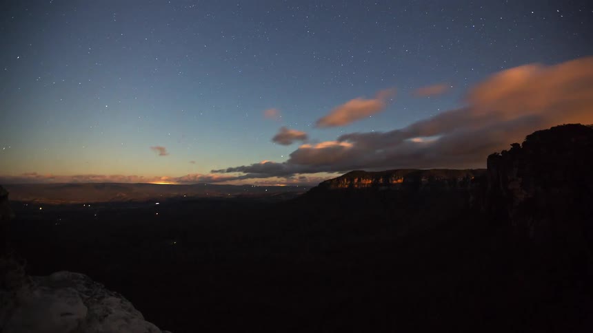 Stars fill the sky as the clouds flow by