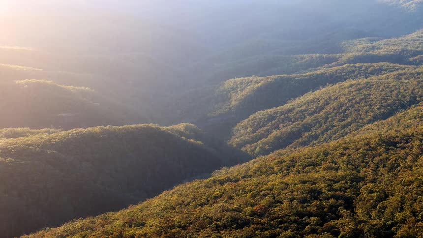 Time lapse of the sun rising on forested hills