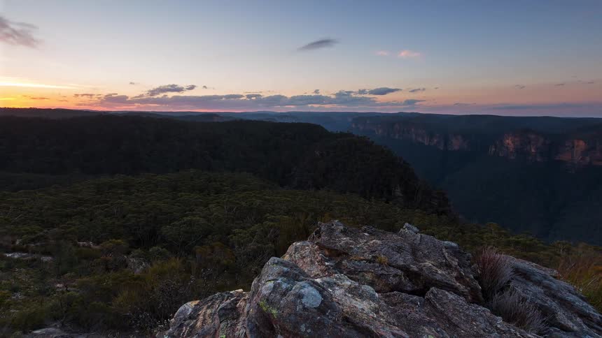 A time lapse of the sun setting over a mountain area