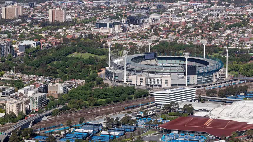 Sports stadium surrounded by urban areas and parks seen from high altitude