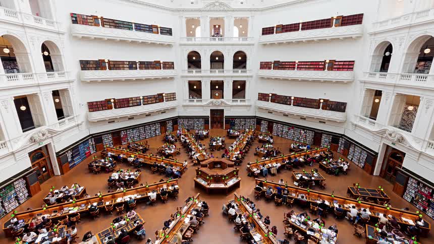A group of people sitting and walking inside the state library victoria in melbourne australia