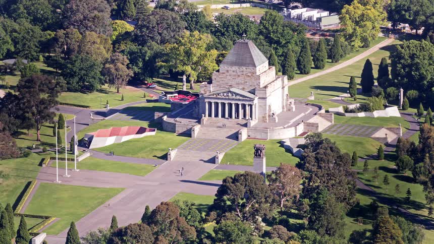 Aerial view of a historic monument surrounded by parkland and pathways in a calm urban green space
