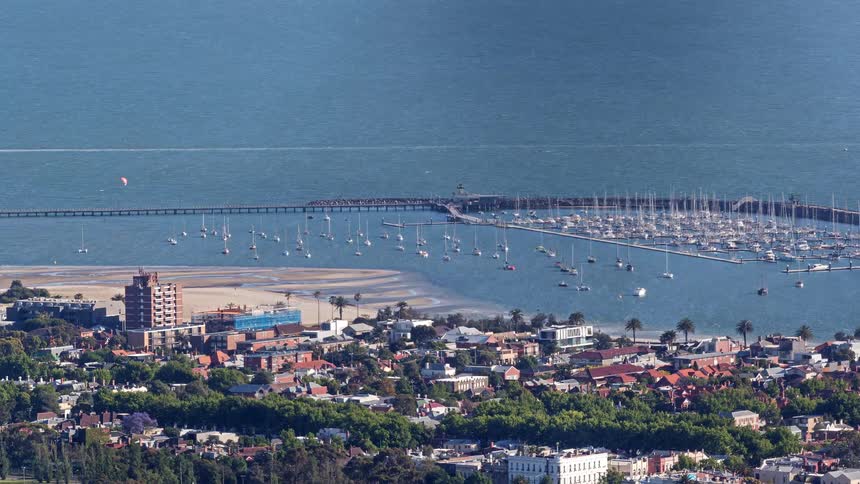 Urban area next to a beach with a marina full of boats outdoors during day time