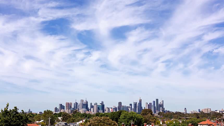 Clouds on the sky over a neigborhood with trees and high rise buildings on a metropolitan area outdoors during day time