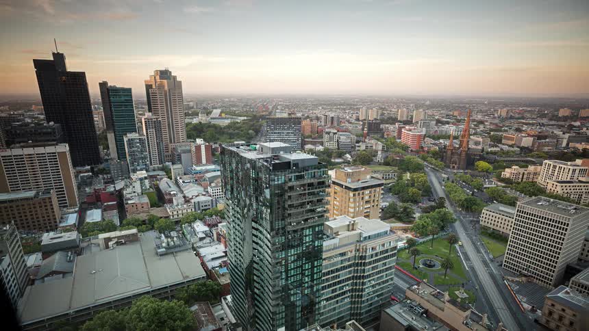 A time lapse of a metropolitan city transitions from daytime to nighttime