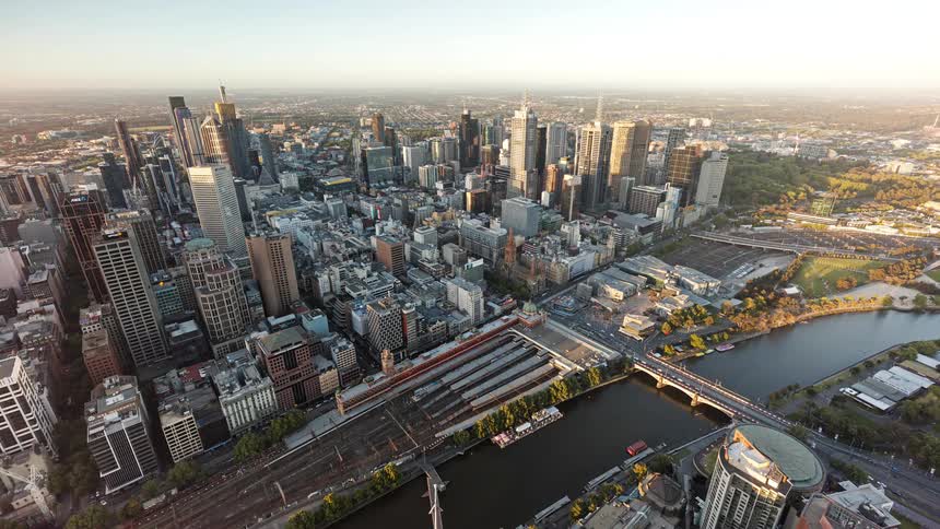 Dense urban center with skyscrapers a river and railway lines seen from high altitude