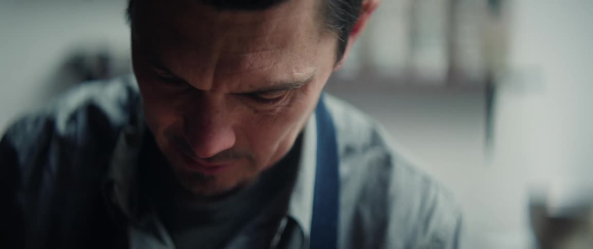 Focused person with apron looking downward