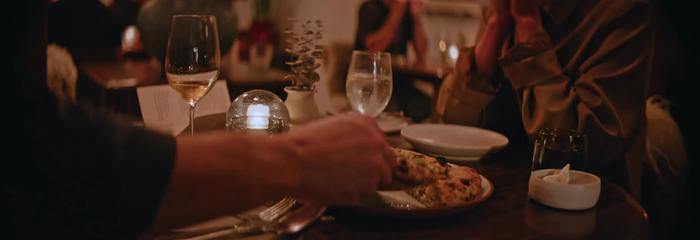 Man and a woman sitting in a restaurant share a meal