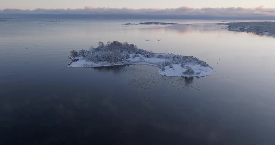 An island covered in snow is close to a coastal area